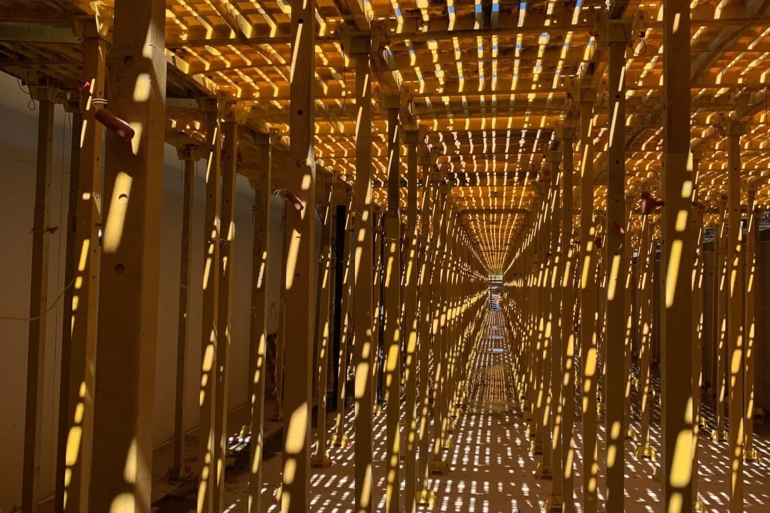 Beneath a Trad Deck platform: rows of yellow leg units in place of a birdcage scaffold
